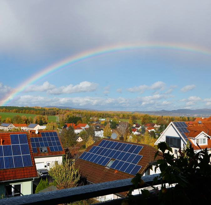 A neighborhood of homes with rooftop solar on a bright day